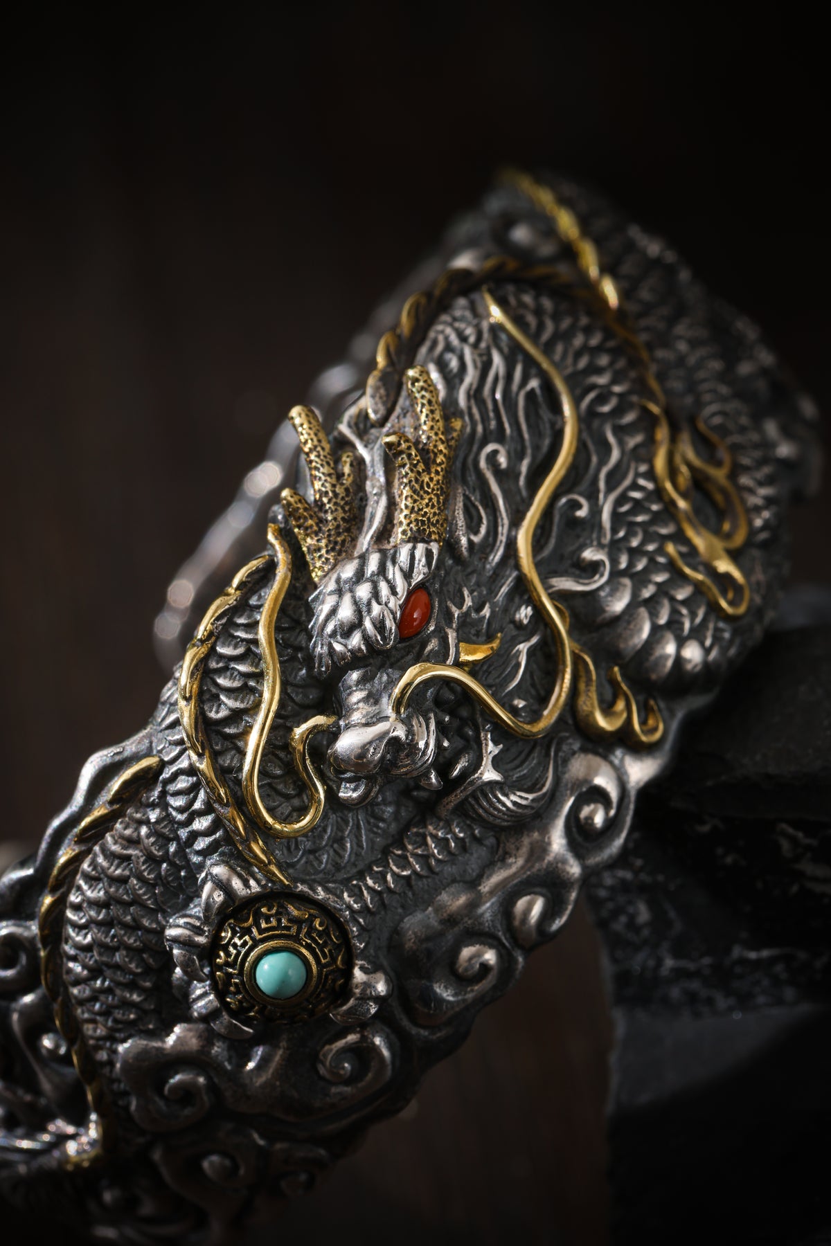 Close-up of the Auspicious Dragon Guardian Bracelet: textured silver scales, gold accents and a red stone eye