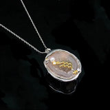 Aquarius crystal geode zodiac pendant with Aquarius symbol, angled view
