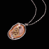 Cancer crystal geode zodiac pendant with Cancer symbol, angled view