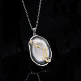Gemini crystal geode zodiac pendant with Gemini symbol, angled view