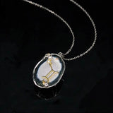 Gemini crystal geode zodiac pendant with Gemini symbol, angled view