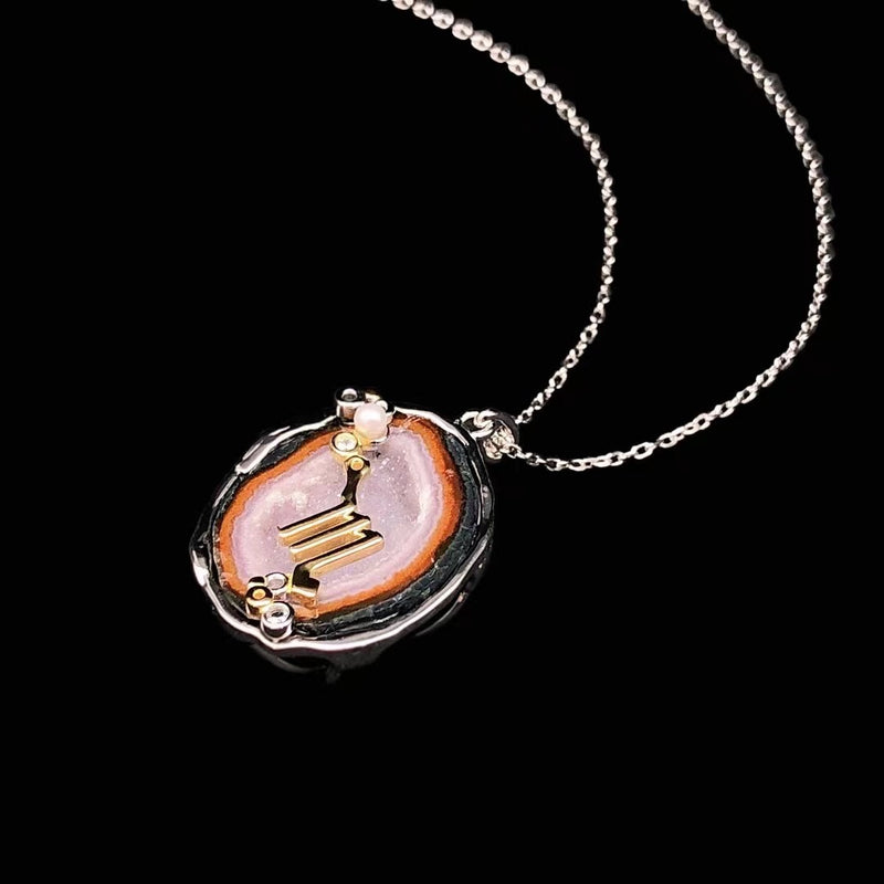 Scorpio crystal geode zodiac pendant with Scorpio symbol, angled view